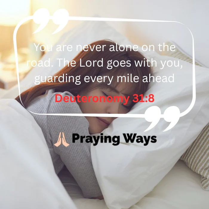 A woman sleeping peacefully on her side in a bright, cozy bed with white linens and striped pillows. A white quote bubble overlays the image containing the text: "You are never alone on the road. The Lord goes with you, guarding every mile ahead" with "Deuteronomy 31:8" highlighted below it in red text.